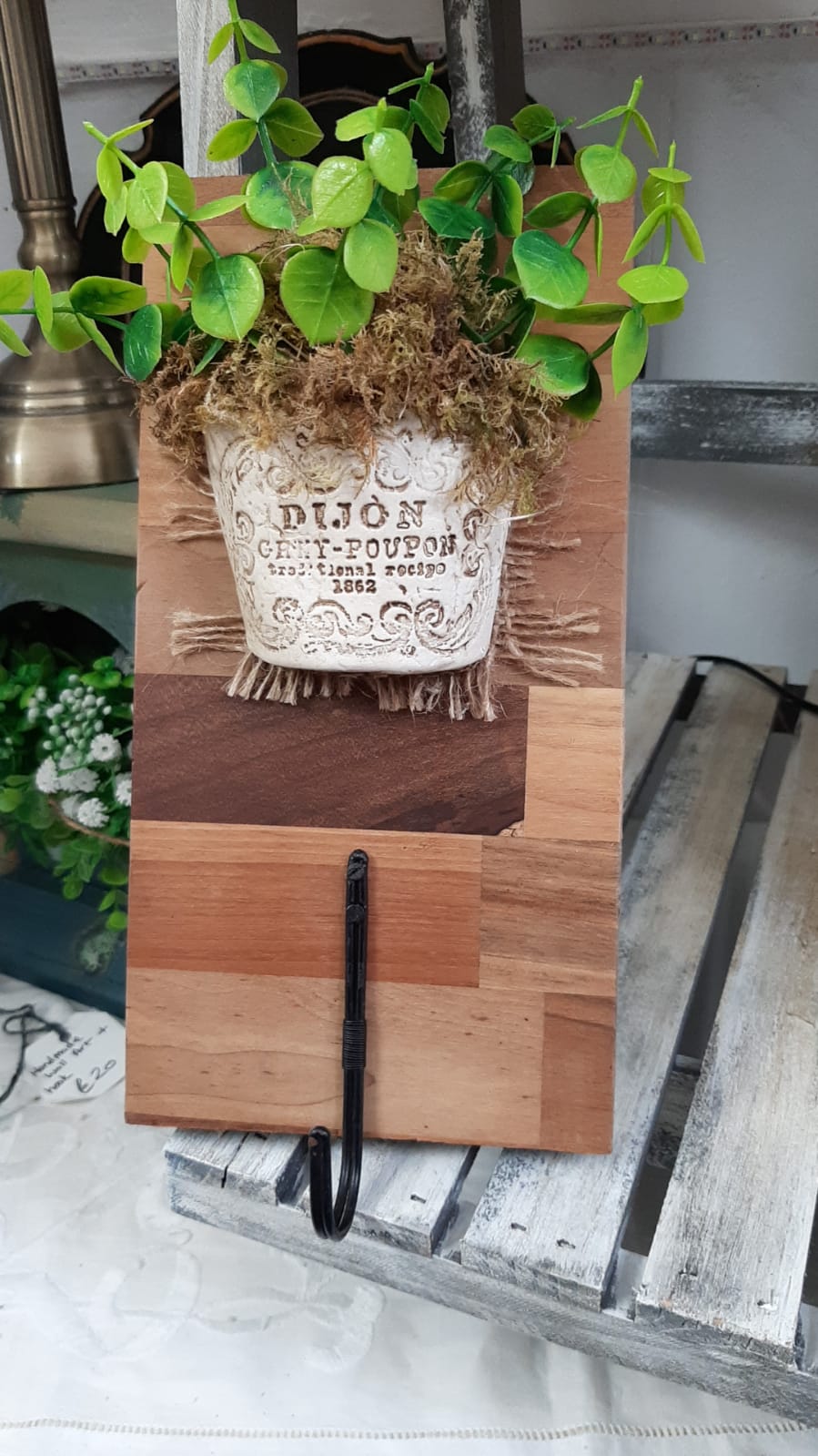 Clay embossed half flower pot on solid wood base with black metal hook. Unique piece.